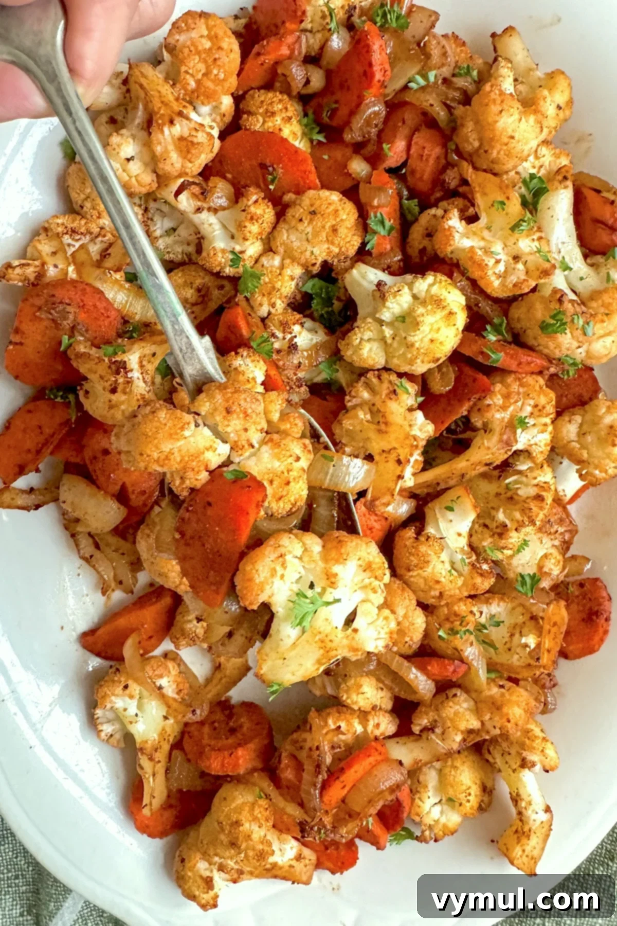 Simple Healthy Chili Roasted Cauliflower and Carrots 2 roasted cauliflower and carrots on white plate with spoon