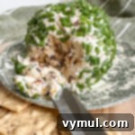 5 Minute Sun Dried Tomato Cheese Ball Quick and Nut Free 9 cutting into cheese ball with a knife