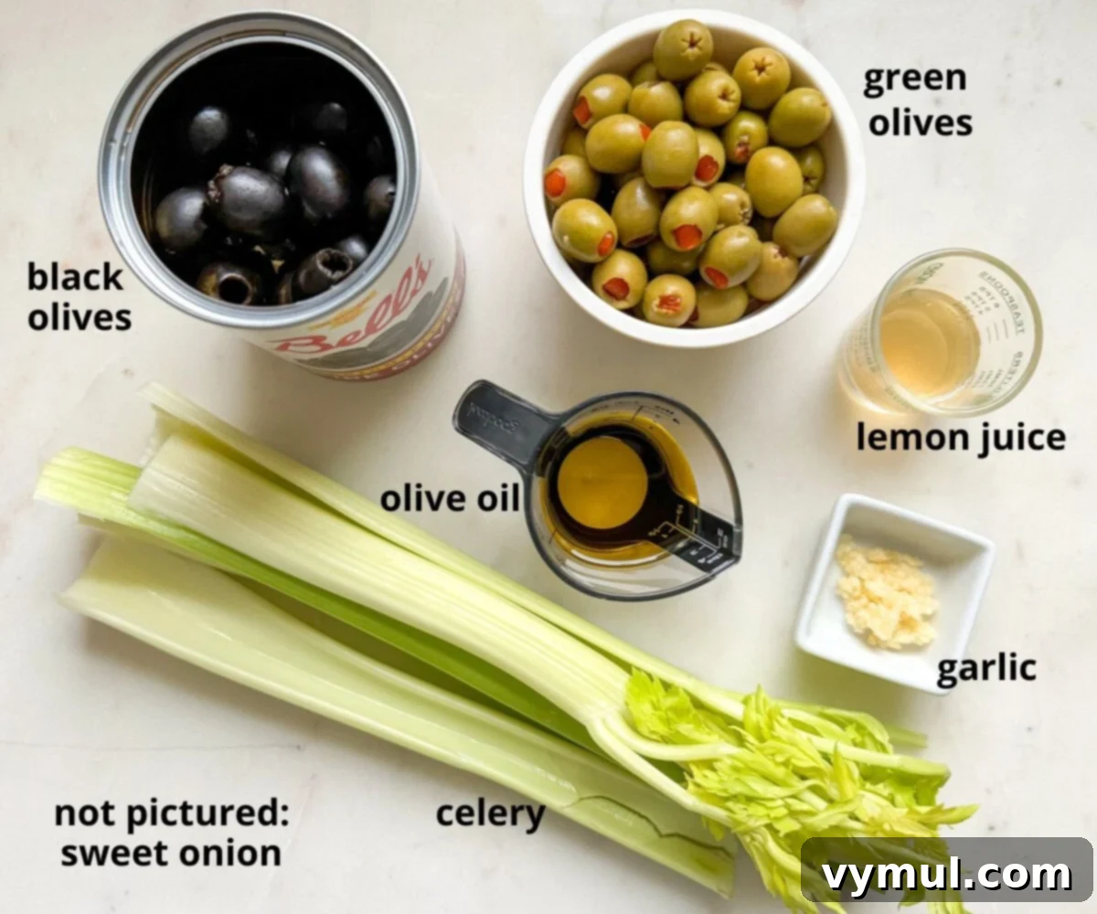 Effortless Olive Salad, Maximum Flavor 3 A collection of fresh ingredients for olive salad, including black and green olives, celery, a lemon, a head of garlic, and a bottle of olive oil, neatly arranged and labeled on a kitchen counter.