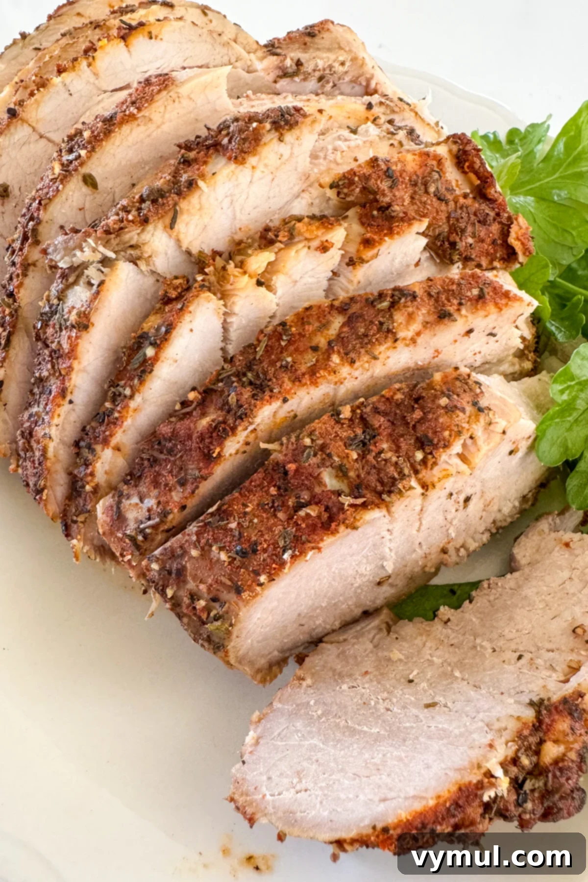 sliced slow cooker pork sirloin on white plate
