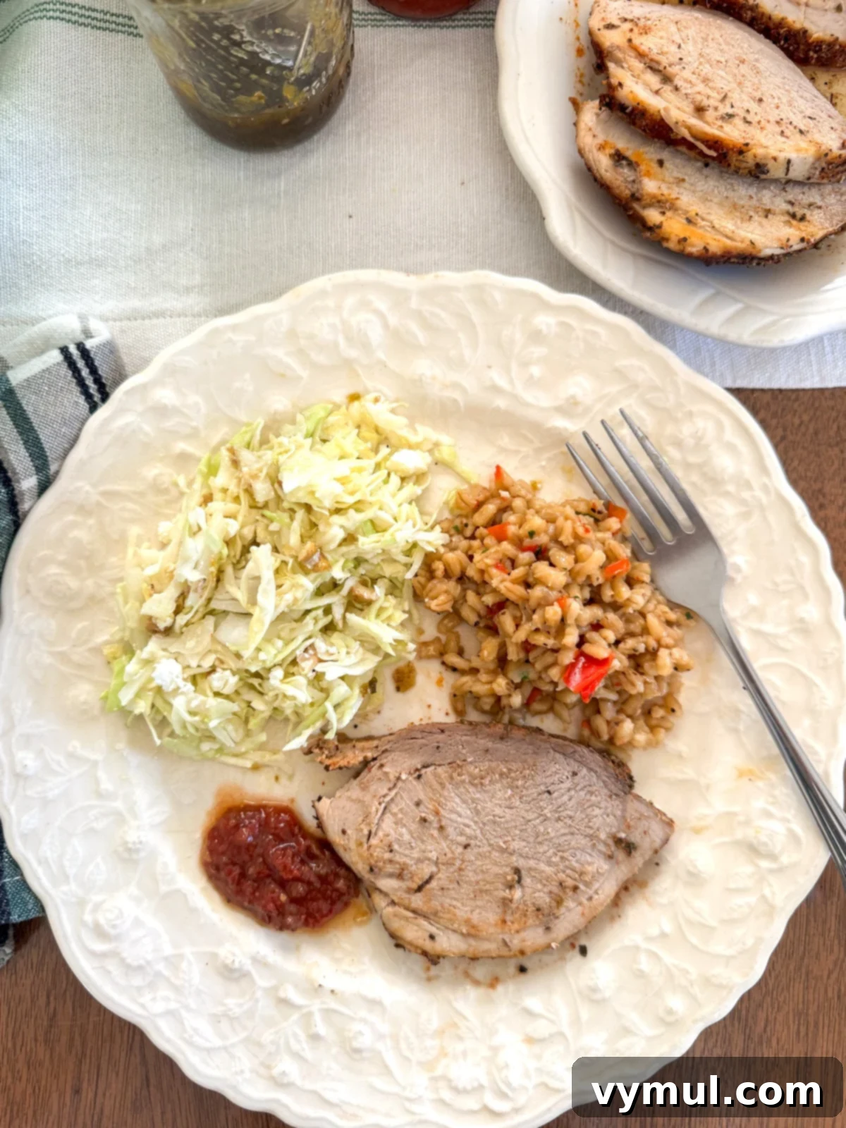 dinner plate with slaw, barley pilaf and sliced pork sirloin roast.