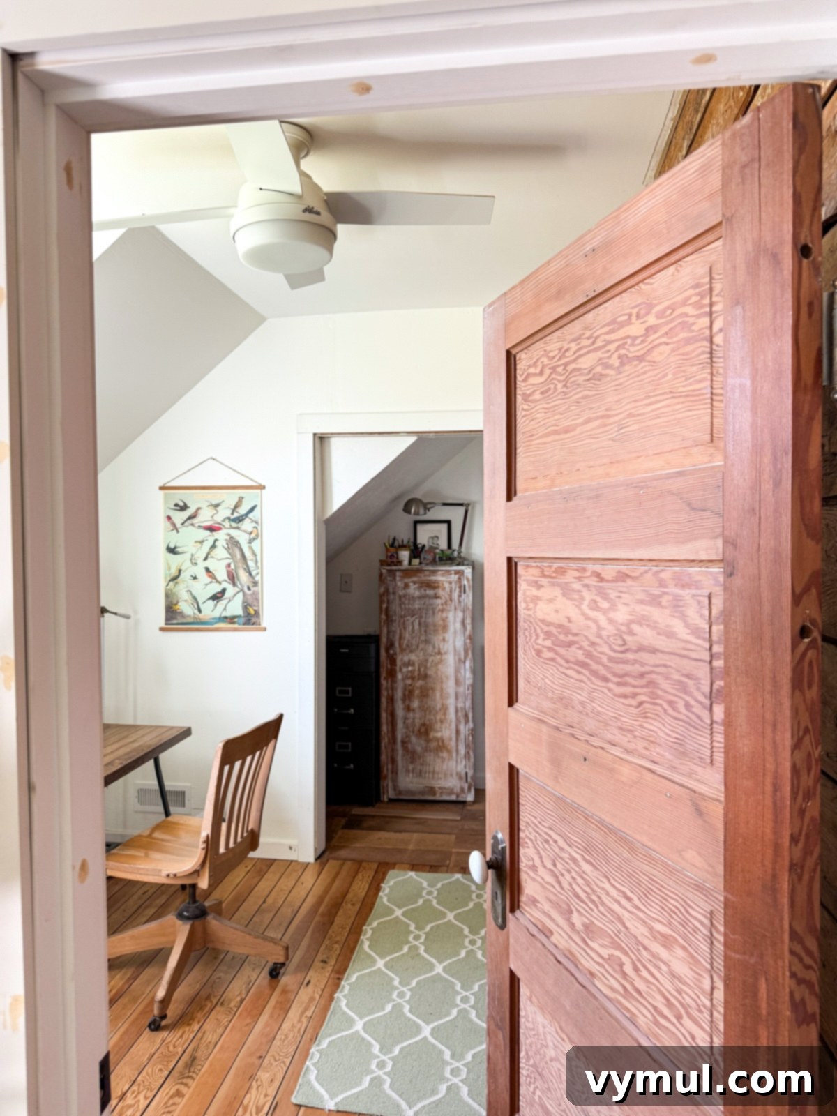 Small, functional office space in a farmhouse, seen from the wooden door and hall.