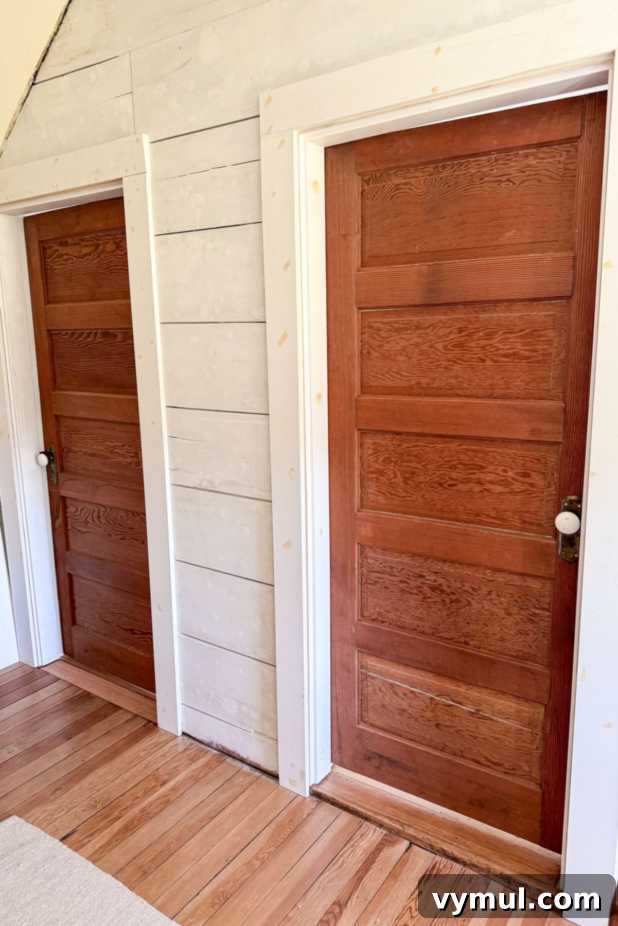 Salvaged vintage wood doors after installation in the remodeled farmhouse bedrooms.