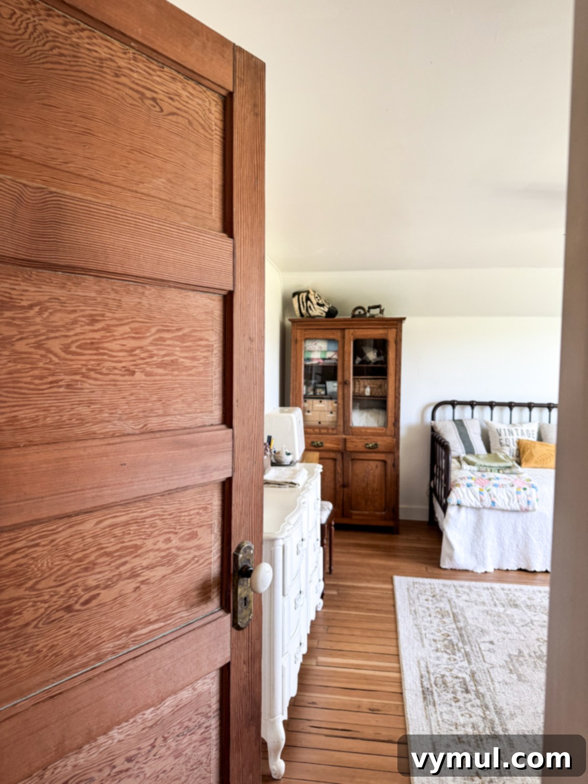 View into a cozy guest room/office from a newly installed vintage wooden door.