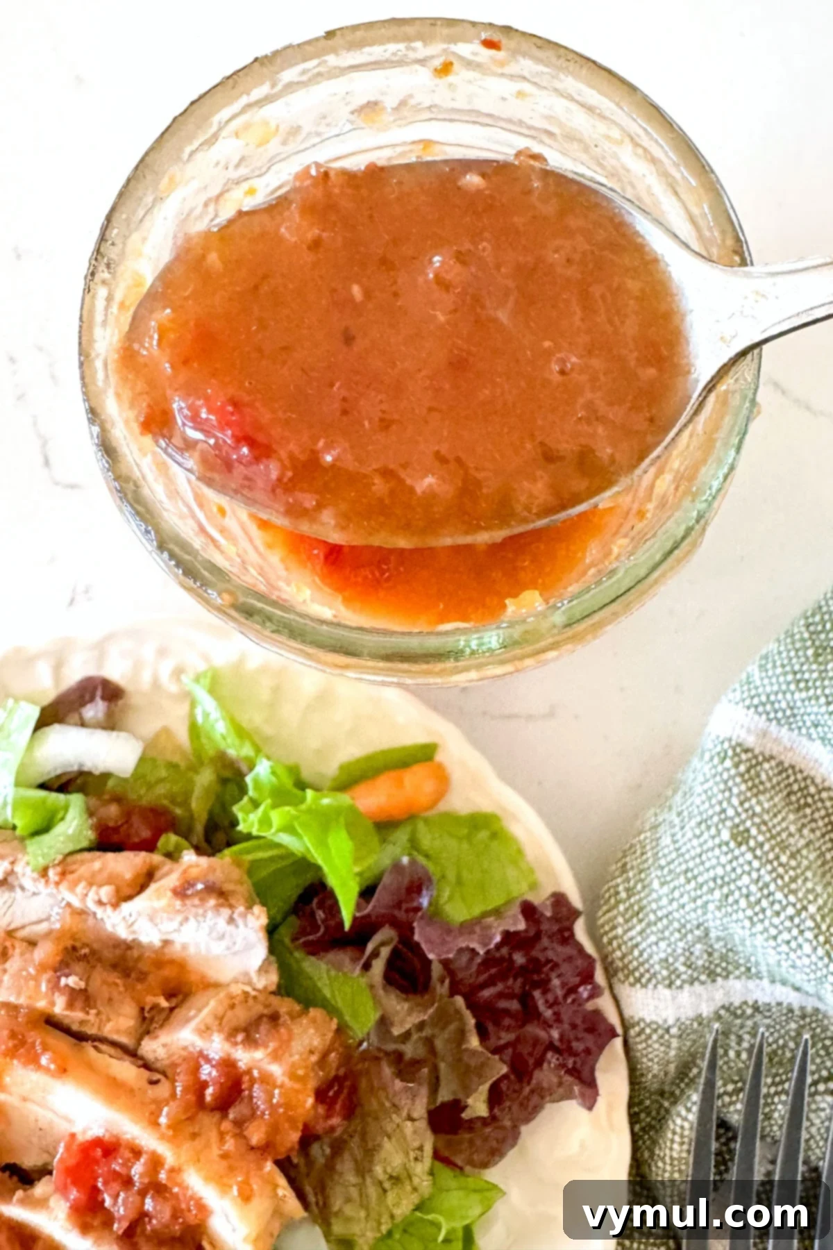 spooning tomato vinaigrette from mason jar