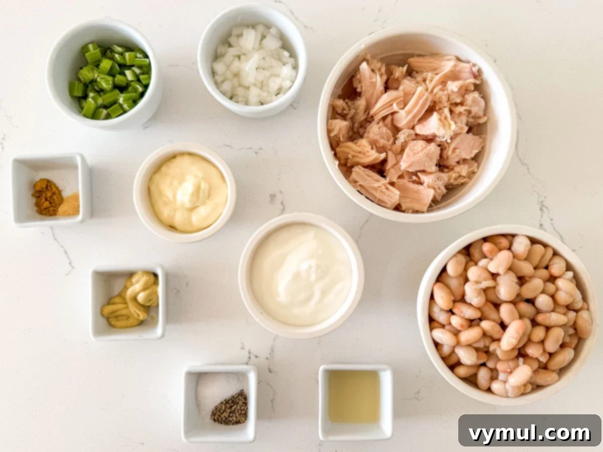 Pantry Powerhouse Protein Chicken Salad 3 Selection of fresh ingredients for a healthy chicken salad, including shredded chicken, white beans, and fresh vegetables.