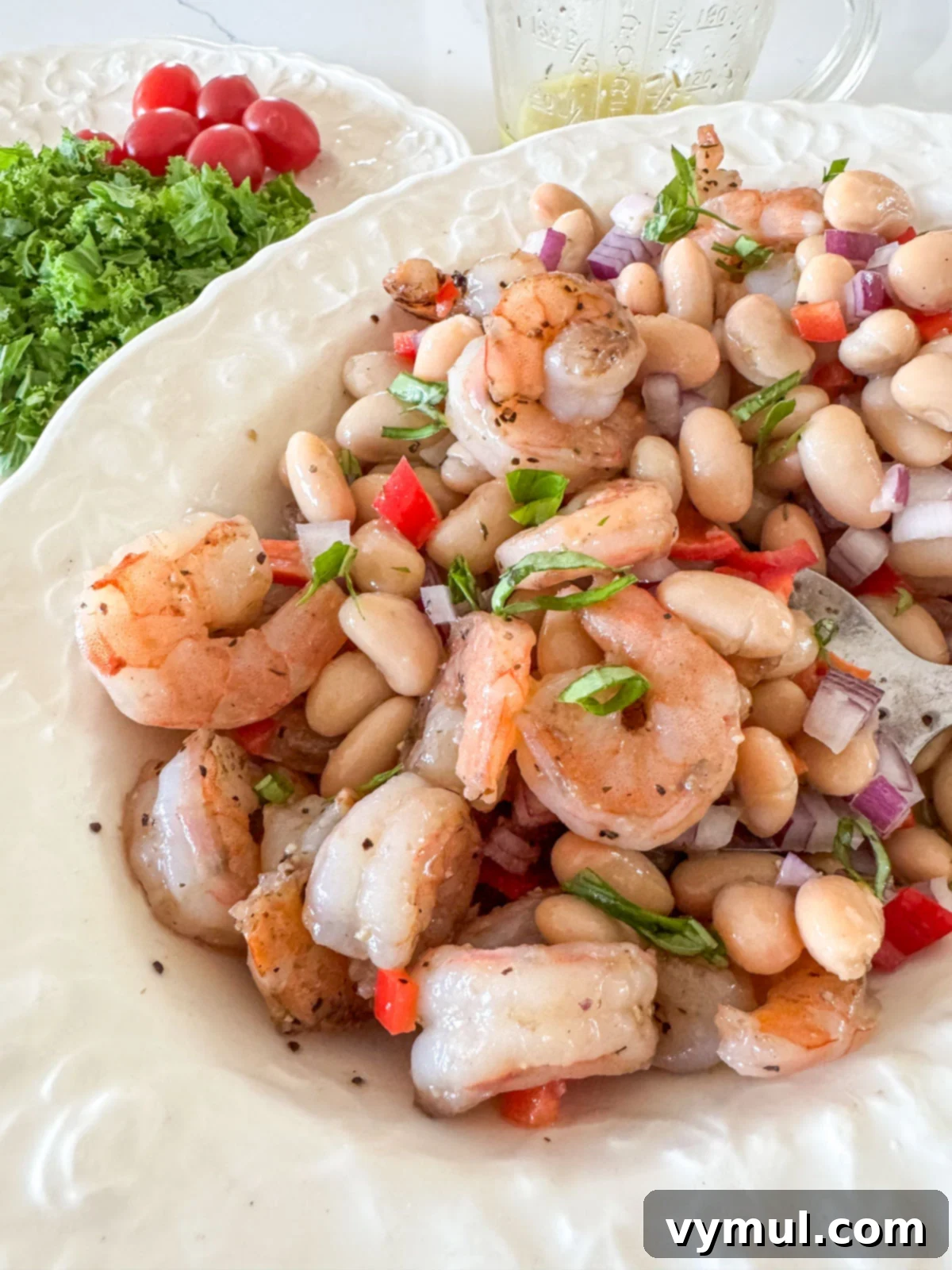 Effortless 15-Minute White Bean Salad with Shrimp or Chicken 4 mixing white bean salad in a bowl