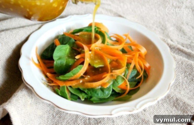 Ditch the Bottle: Fresh & Flavorful Dressings 8 A hand pouring a golden Homemade Sesame Vinaigrette salad dressing from a jar over a fresh green salad.