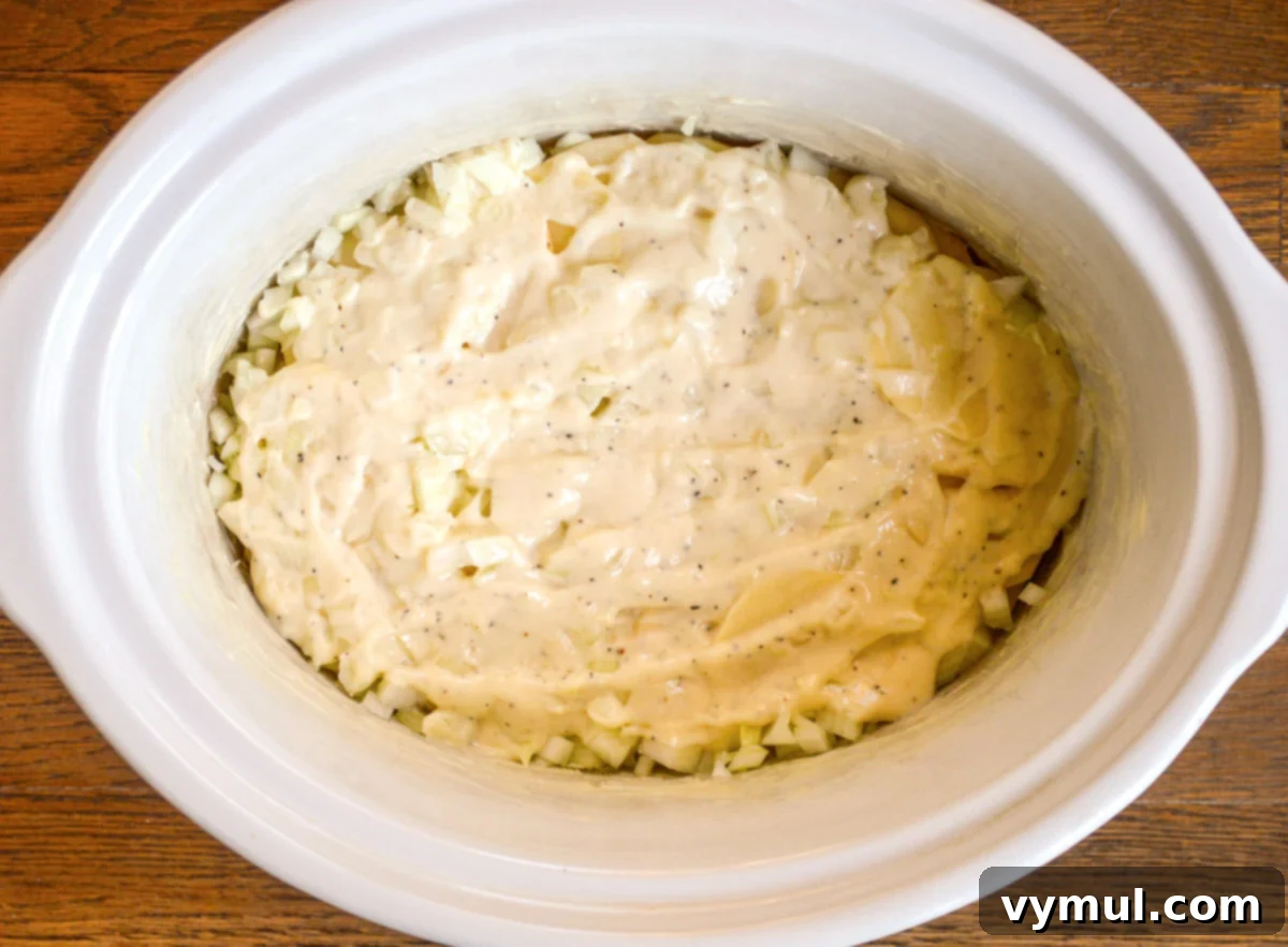 Irresistible Slow Cooker Cheesy Garlic Scalloped Potatoes 6 sauce layer over potatoes in slow cooker