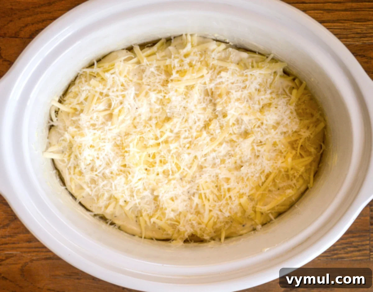 Irresistible Slow Cooker Cheesy Garlic Scalloped Potatoes 7 last layer with cheese in slow cooker