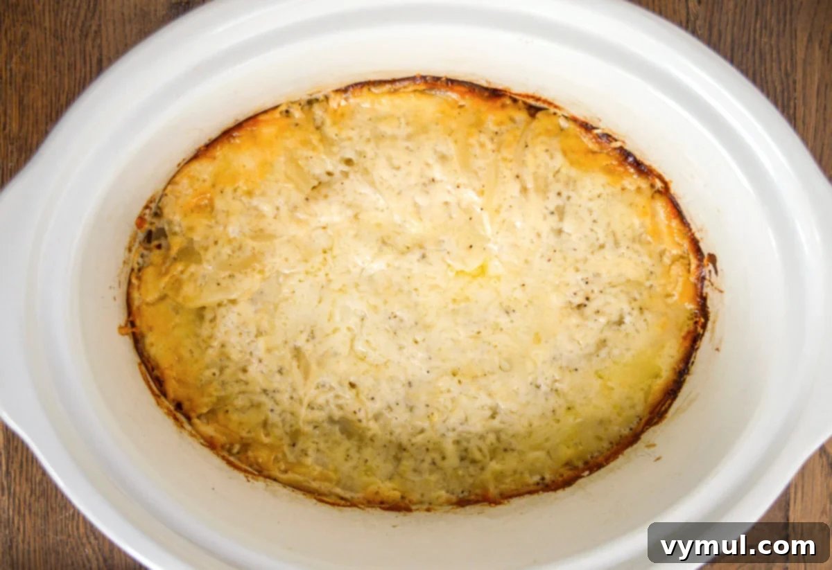 Irresistible Slow Cooker Cheesy Garlic Scalloped Potatoes 8 cooked scalloped potatoes in crockpot above