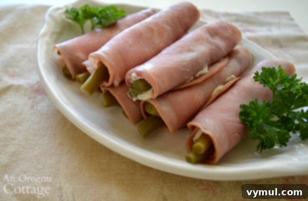 Tangy Low Carb Bean Wraps 3 Quick pickled bean appetizer roll-ups made with ham and cream cheese, served on a rustic board.