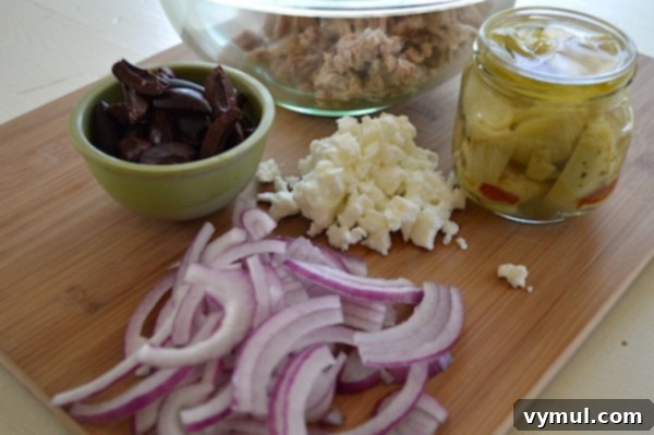 Zesty Greek Tuna Salad with Feta, Olives, and Artichokes 3 Ingredients for Greek Tuna Salad: Canned tuna, artichokes, olives, feta, red onion, garlic, parsley, olive oil, red wine vinegar, Dijon mustard, salt, pepper.