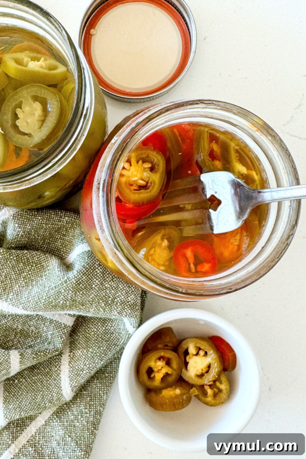open jar of pickled jalapeños with a fork