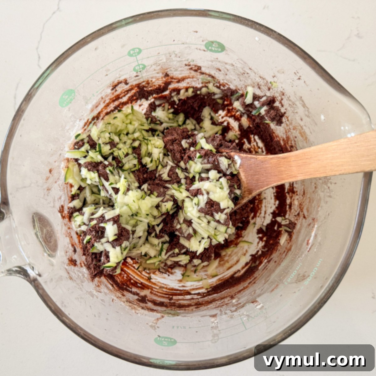 Mixing shredded zucchini into chocolate cookie dough