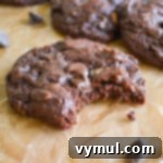 Fudgy zucchini cookie with a bite taken out, showing the soft chocolate interior and hints of zucchini.