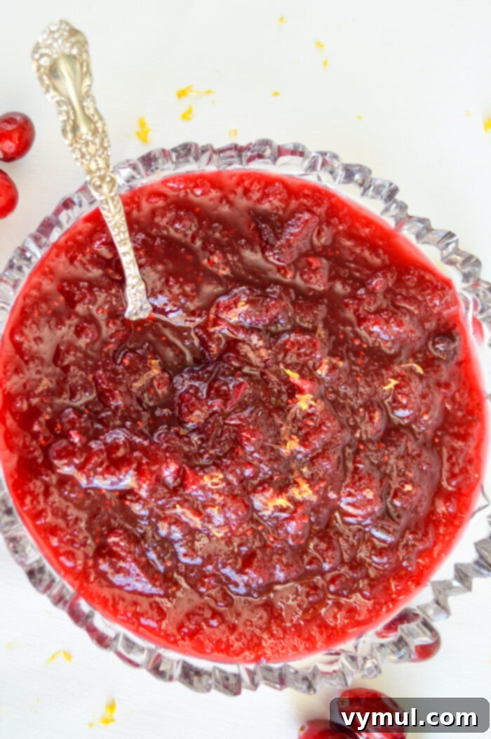 Best Homemade Cranberry Sauce Sweetened with Maple Syrup 5 cranberry sauce recipe in glass bowl with spoon