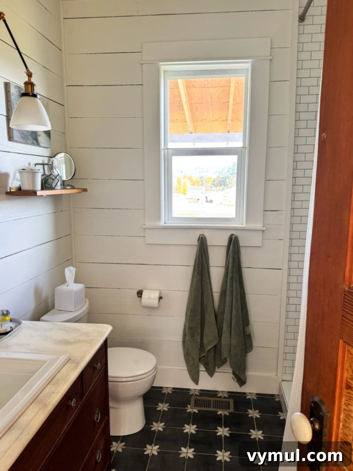 Bathroom window before the installation of a cafe curtain, showing an unobstructed view